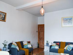 a living room with two couches and a table at Market Place View in Knaresborough