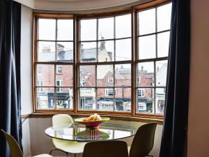 a table and chairs in front of a large window at Market Place View in Knaresborough