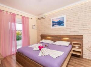 a bedroom with a purple bed with pink curtains at Villa Goldfield in Gradac