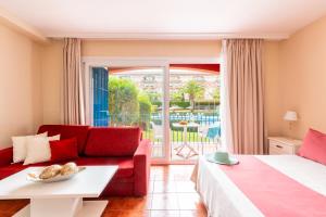 a hotel room with a red couch and a patio at Leo Islamar in Islantilla +56 photos