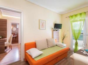 a living room with an orange couch in a room at Villa Goldfield in Gradac