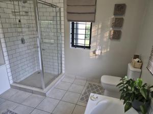 a bathroom with a shower and a toilet at Courtleigh Cottage in Hilton +23 photos