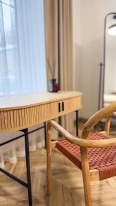 a wooden table and a chair next to a desk at ATRIUM City Center Apartment in Kaunas