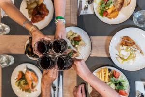 a group of people drinking wine at a table with food at Hotel - Bungalows Don Juan Tossa in Tossa de Mar
