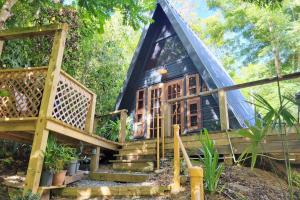 a tree house with stairs leading up to it at Romantic Cozy Serene A Frame Mountain Cabin in Cayey