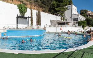 a group of people swimming in a swimming pool at Hotel - Bungalows Don Juan Tossa in Tossa de Mar