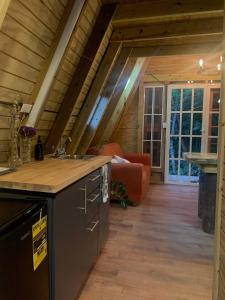 a kitchen and living room in a log cabin at Romantic Cozy Serene A Frame Mountain Cabin in Cayey