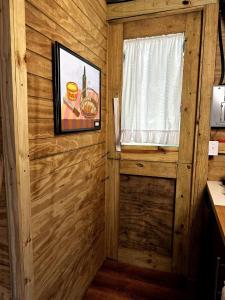 a room with a wooden wall with a window and a picture at Romantic Cozy Serene A Frame Mountain Cabin in Cayey
