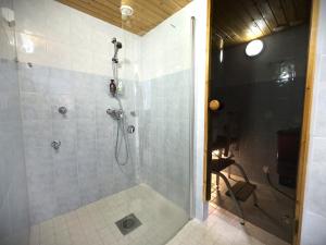 a bathroom with a shower with a glass door at Riihen Pirtti in Äkäslompolo