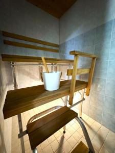 a wooden shelf in a bathroom with a bucket on it at Riihen Pirtti in Äkäslompolo +1 photo