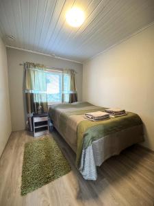 a bedroom with a bed and a window at Riihen Pirtti in Äkäslompolo