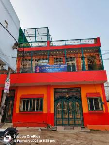 an orange building with a gate on top of it at Vraja Kishori Sewa Dham in Vrindāvan
