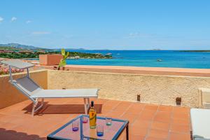 a patio with a table and a chair and the ocean at Marineledda la terrazza sul golfo in Santa Marinella