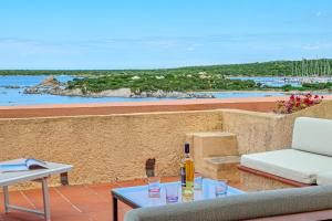 a patio with a couch and a table with wine glasses at Marineledda la terrazza sul golfo in Santa Marinella