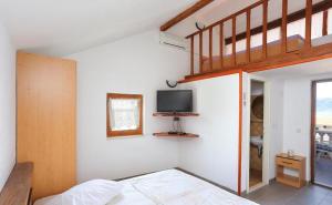 a bedroom with a bed and a tv on the wall at Apartmani Suzi in Slatine