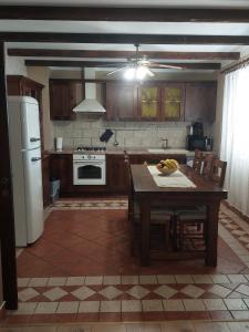 a kitchen with a table and a white refrigerator at Villa Nicoletta in Polača
