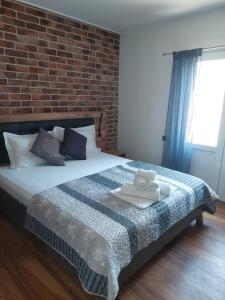 a bedroom with a large bed with a brick wall at Villa Nicoletta in Polača +24 photos