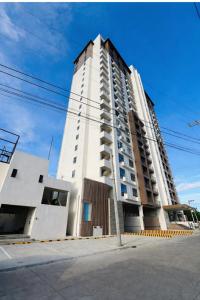 a tall white apartment building on a street at JZA Staycation 1 in Mactan