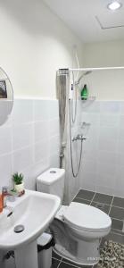 a bathroom with a shower and a toilet and a sink at JZA Staycation 1 in Mactan
