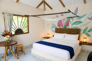 a bedroom with a bed and a flower wall at Pomelo Hostal in Mingueo