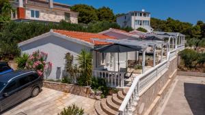 a car parked in front of a house with an umbrella at Perla Mare in Sumartin