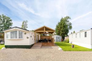 a caravan conversion with a deck and a house at Camping Papillon Kinrooi 113 in Kinrooi