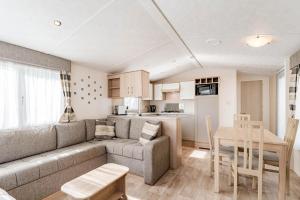 a living room and kitchen with a couch and a table at Camping Papillon Kinrooi 113 in Kinrooi