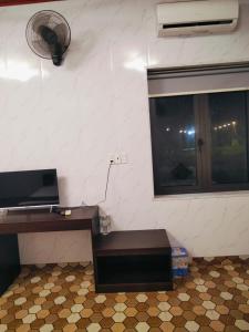 a room with a desk with a fan and a window at Mũi Si Homestay Cửa Tùng in Vĩnh Bang