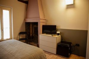a bedroom with a bed and a tv and a fireplace at Casa Gotica in Castelfranco Emilia