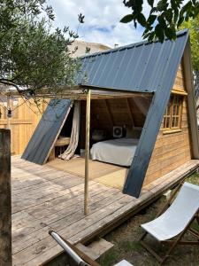 a bed in a tiny house on a deck at Le tipi d'Hamih in Uzès