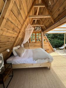a bed in the attic of a wooden house at Le tipi d'Hamih in Uzès +3 photos