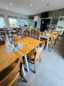 a dining room with wooden tables and chairs at Die Schlafstube - Boutiquehotel in Neuharlingersiel