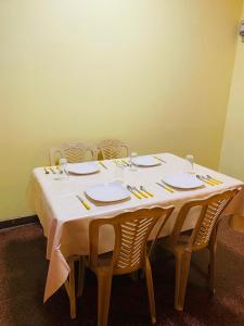 a table with chairs and a white table cloth at SAMA TOURIST guest in Seeduwa