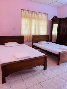 two beds sitting in a room with a window at SAMA TOURIST guest in Seeduwa
