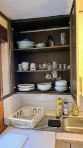 a kitchen cabinet with dishes and plates in it at Monteurzimmer Nähe Pforzheim in Engelsbrand +13 photos