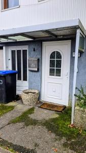 a house with a white door and a trash can at Monteurzimmer Nähe Pforzheim in Engelsbrand