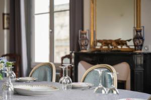 a dining room table with plates and glasses on it at Maison bourgeoise, Rives du Cher, 14 pers in Montrichard