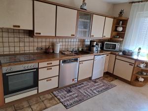 a kitchen with white appliances and wooden cabinets at Ferienwohnung Lene im Lauertal - Rhön in Maßbach