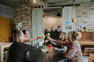 a group of people sitting around a table with glasses of champagne at Slapen op de Dijk - Tiny House in Kraggenburg