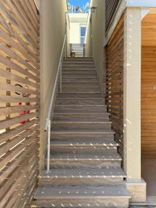 a staircase leading up to a house with a wooden wall at Acquaviva Suites, Pool - View in San Vincenzo
