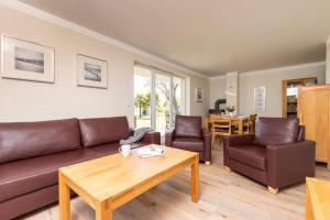 a living room with a couch and chairs and a table at Sassnitz - Kamin, Meerblick, Sauna, Fitness - FeWo Haubentaucher in Sassnitz