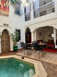 a house with a swimming pool and a table and chairs at Riad FARASHA & Pool-Rooftop View in Marrakesh