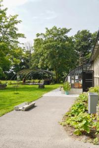 a park with a bench and a glass greenhouse at Slapen op de Dijk - Tiny House in Kraggenburg