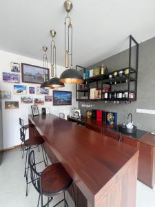 a kitchen with a large wooden bar with chairs at Lumiere Villa, Kandy in Nugawela