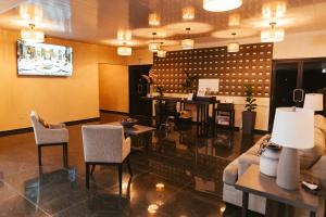a living room with a couch and tables and chairs at Hotel Plaza Los Tucanes in Santiago
