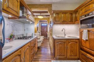 a kitchen with wooden cabinets and a sink and a stove at Charming City Stay close to Seafront in Birgu