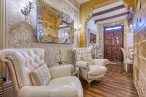 a salon with white chairs and a mirror at Charming City Stay close to Seafront in Birgu