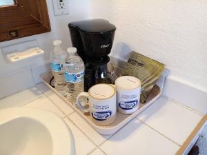 a tray with coffee cups and water bottles on a counter at Club Cantamar Beach Hotel & Marina in La Paz