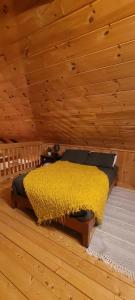 a bedroom with a yellow bed in a wooden ceiling at Ohana cabin in Hanover