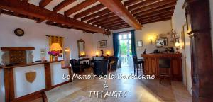 a large living room with a table and chairs at Hôtel De La Barbacane in Tiffauges